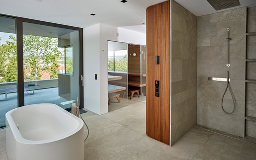 Espace bien-être privé : Des matériaux assortis dans tout l'espace bien-être : outre le sauna, on y trouve également une douche à effet pluie raffinée et une baignoire sur pied.