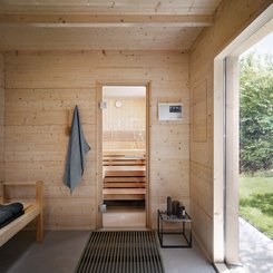 Sauna extérieur TALO : hall d'entrée avec fenêtre panoramique et vue sur le sauna.