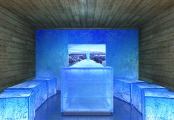 KLAFS ICE LOUNGE avec écran simple ATMOSPHERE, fontaine à glace STALAGMIT, cube d'assise en verre acrylique, mur et plafond en vieux bois.