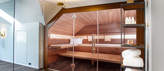 Sauna design sous la pente du toit avec éclairage indirect et architecture d’intérieur moderne